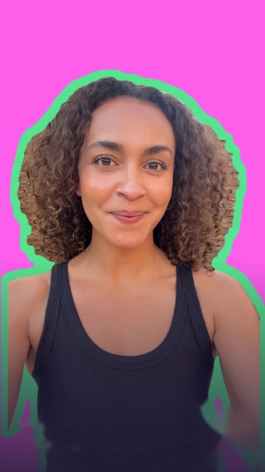 Woman with curly hair smiling at the camera